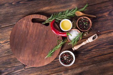 Tuz, karabiber, biberiye dalı ahşap masa üzerinde kırmızı acı biber. en üstteki görünüm