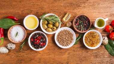 Tahta bir masada farklı baharatlar ve sebzeler. İtalyan yemek malzemeleri. en üstteki görünüm