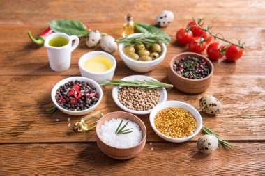 Tahta bir masada farklı baharatlar ve sebzeler. İtalyan yemek malzemeleri..