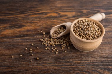 Masadaki ahşap kasede kişniş tohumları.