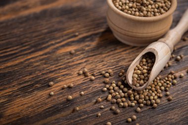 Masadaki ahşap kasede kişniş tohumları.