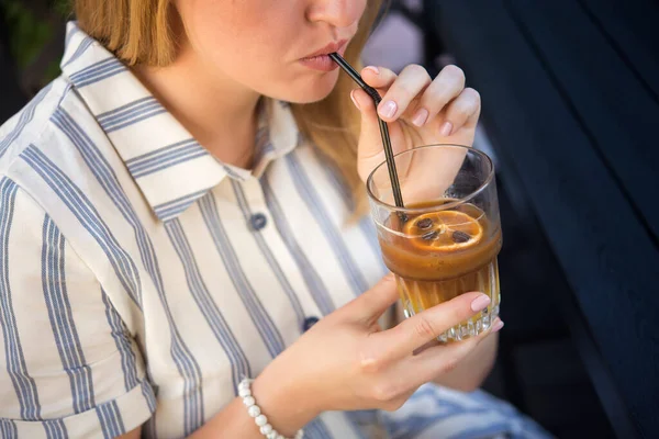 Elinde kahve çekirdekleri ve portakal dilimli soğuk yaz kokteyli tutan bir kadın. Yaşam tarzı insan kavramı.