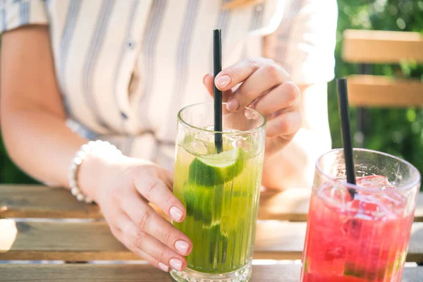 Genç ve güzel bir kız kafedeki ahşap masada soğuk içecek kokteyli içiyor. Yaz yaşam tarzı insanları.