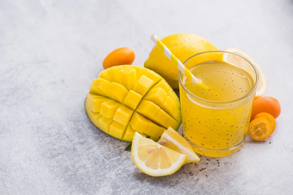 Diyet detoks içeceği, chia tohumu, mango, limon ve kumkuat meyveleri ile taş bir masada. Taze egzotik içecek. Boşluğu kopyala.
