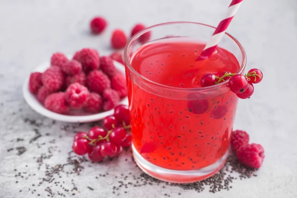 Taze yaz arınma kokteyli kırmızı frenk üzümü, ahududu ve çim tohumlarıyla taş bir masada..