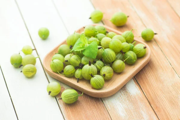Tahta bir masada naneli taze ve doğal bektaşi üzümü. Böğürtlen organik, vitamin yiyecekleri.