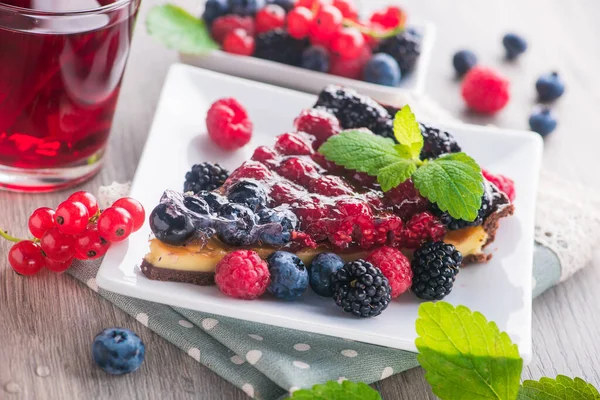 Taze böğürtlenli, ahududulu, üzümlü, yaban mersinli ve yeşil naneli tatlı pasta..