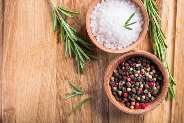 Baharat, tuz ve siyah kâğıt, biberiye ve ahşap bir masada. en üstteki görünüm