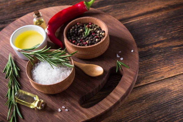 Tuz, karabiber, biberiye dalı, tahta kesme masasında kırmızı acı biber..