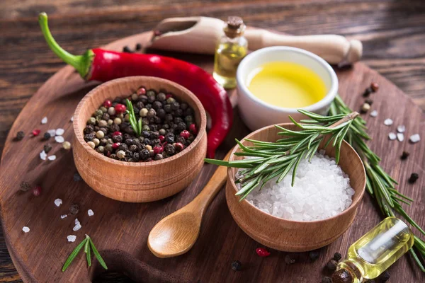 Tuz, karabiber, biberiye dalı, tahta kesme masasında kırmızı acı biber..