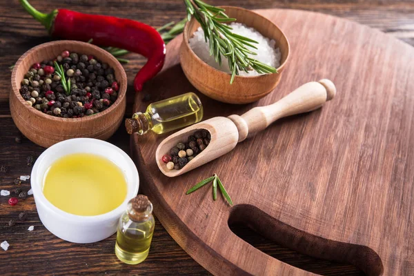 Tuz, karabiber, biberiye dalı, tahta kesme masasında kırmızı acı biber..