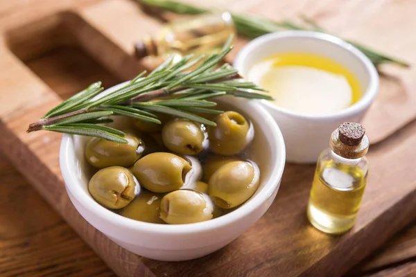 Biberiye ve zeytinyağını ahşap bir arka planda bir kaseye koy..