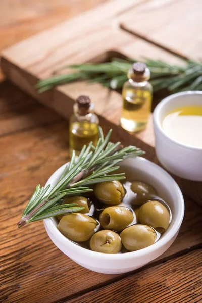 Biberiye ve zeytinyağını ahşap bir arka planda bir kaseye koy..