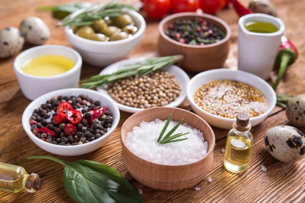 Tahta bir masada farklı baharatlar ve sebzeler. İtalyan yemek malzemeleri..