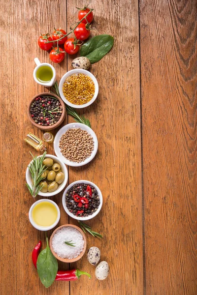 Tahta bir masada farklı baharatlar ve sebzeler. İtalyan yemek malzemeleri. Üst Manzara. metin için boşluk kopyala