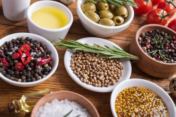 Tahta bir masada farklı baharatlar ve sebzeler. İtalyan yemek malzemeleri..