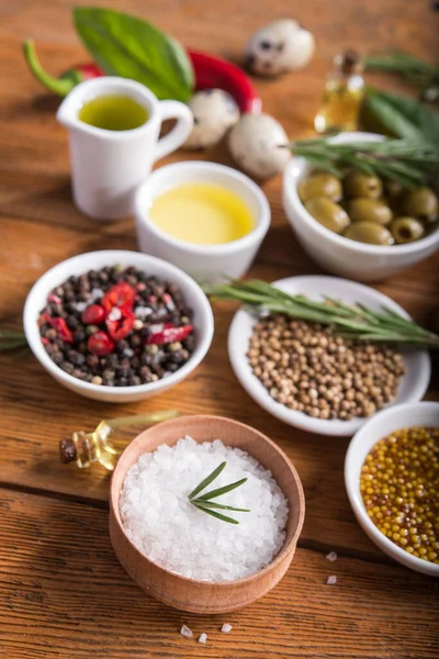 Tahta bir masada farklı baharatlar ve sebzeler. İtalyan yemek malzemeleri..