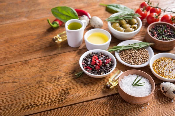 Tahta bir masada farklı baharatlar ve sebzeler. İtalyan yemek malzemeleri. metin için boşluk kopyala