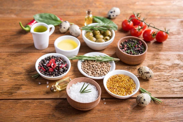 Tahta bir masada farklı baharatlar ve sebzeler. İtalyan yemek malzemeleri..