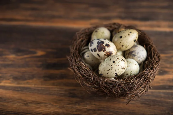 Yuvadaki bıldırcın yumurtaları ahşap bir arka planda..