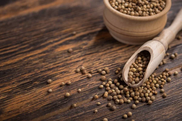 Masadaki ahşap kasede kişniş tohumları.