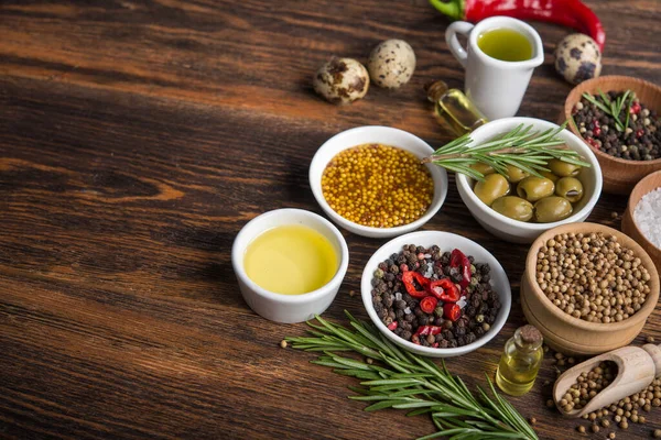 Tahta bir masada farklı baharatlar ve sebzeler. İtalyan yemek malzemeleri..