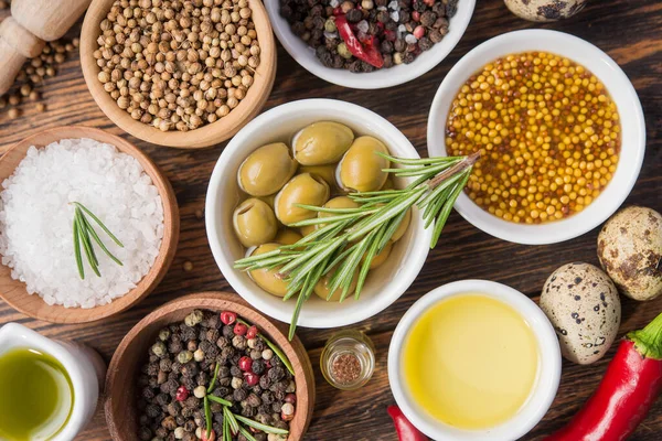 Tahta bir masada farklı baharatlar ve sebzeler. İtalyan yemek malzemeleri. en üstteki görünüm