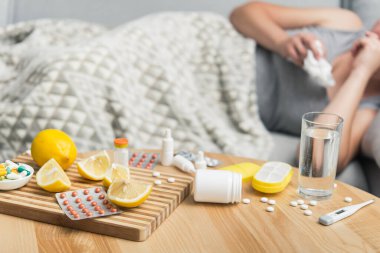 Soğuk algınlığı ve grip olan genç bir kadın. Evde kendi kendini tedavi ediyor. Vitamin ve haplarla. Alerji yüzünden burnu ağrıyor..