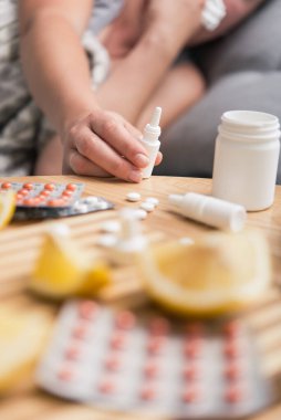 Genç kız üşütmüş ve grip olmuş, evde tedavi edilmiş, burun spreyi kullanıyor..