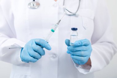 Klinikte elinde grip aşısı tutan kadın doktor. Hastanede doz aşısı..
