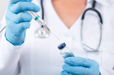 Klinikte elinde grip aşısı tutan kadın doktor. Hastanede doz aşısı..