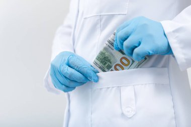 Klinikteki doktor bir tomar banknotla. Tıpta yolsuzluk ve rüşvet. Ücretli tedavi.