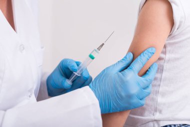 Çocuk doktoru küçük bir çocuğa şırınga ile grip aşısı yaptı. Koruyucu bağışıklık. sağlık hizmeti kavramı.