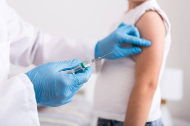 Çocuk doktoru küçük bir çocuğa şırınga ile grip aşısı yaptı. Koruyucu bağışıklık. sağlık hizmeti kavramı.