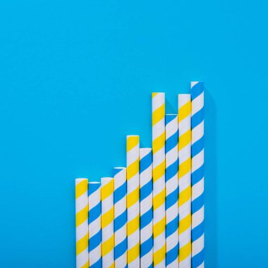 Mavi arka planda parlak renkli kokteyl pipeti. Geri dönüşüm ekosu konsepti. en küçük biçim.