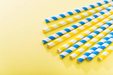 Renkli arka planda parlak sarı renkli kokteyl pipeti. Geri dönüşüm ekosu konsepti. en küçük biçim.