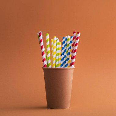 Renkli arka planda kağıt bardakta parlak renkli kokteyl pipeti. Geri dönüşüm ekosu konsepti. pop sanat tarzı.