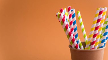 Renkli arka planda kağıt bardakta parlak renkli kokteyl pipeti. Geri dönüşüm ekosu konsepti. pop sanat tarzı.