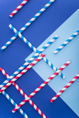 Mavi arka planda kağıt bardakta parlak renkli kokteyl pipeti. Geri dönüşüm ekosu konsepti. pop sanat tarzı.