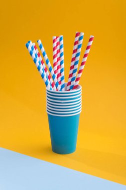 Renkli arka planda kağıt bardakta parlak renkli kokteyl pipeti. Geri dönüşüm ekosu konsepti. pop sanat tarzı.