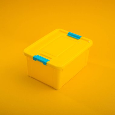 Sarı arka planda plastik bir kutu. Okul beslenme çantası.