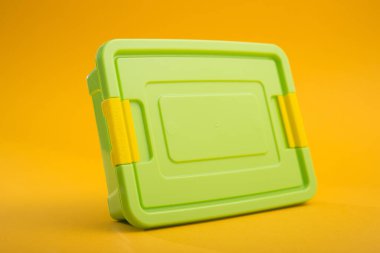 Sarı arka planda plastik bir kutu. Okul beslenme çantası.