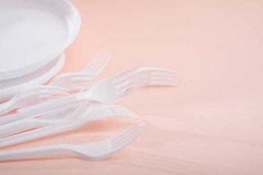 Pastel bir arkaplan üzerinde plastik tablo malzemesi kullanımını azaltmak için yaratıcı bir kavram.