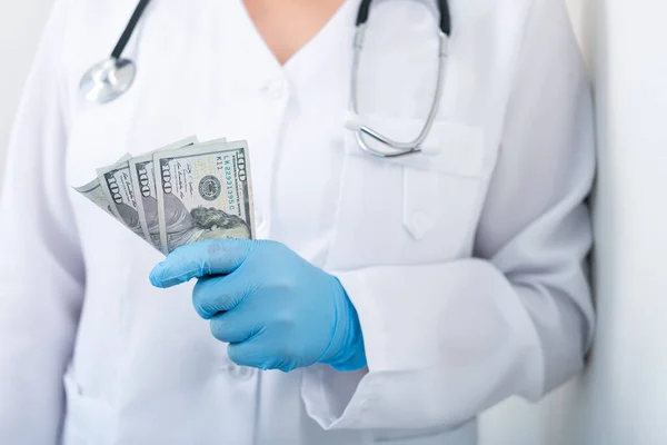 医生在诊所拿着一堆美元的钞票 药品中的腐败和贿赂 有偿治疗 — 图库照片