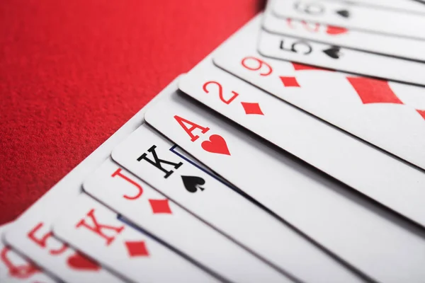 Kumarhanede Kırmızı Masada Poker Oynamak Için Bir Deste Kağıt — Stok fotoğraf