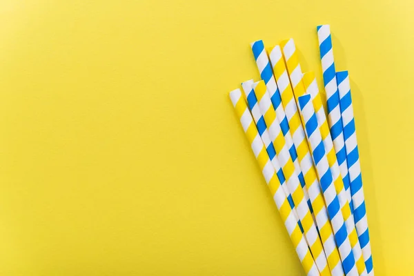 Bright yellow colored cocktail straw on a color background. recycling eco concept. minimal style. flat lay. top