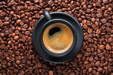 Taze demlenmiş Brezilya espresso kahvesi, siyah bir fincanda kavrulmuş fasulye, üst manzara..