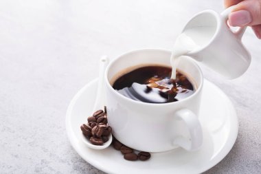 Süt kreması beyaz bir kahve bardağına dökülür.