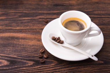 Ahşap zemin üzerinde kahve olan beyaz bardak. metin için boşluk kopyala