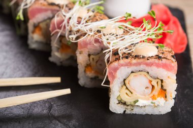 Siyah bir arka planda somonlu suşi rulosu. Japon yemek menüsü